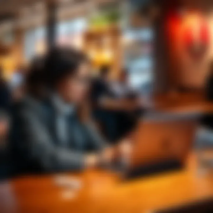 Two people looking at a laptop, considering low-fee methods to withdraw $200 while sitting in a cafe